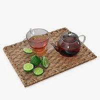 Glass Teapot with Tea Cup and Bergamot on Rattan Mat