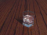 Glass with ice cubes on table