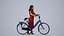 00343Anisa011 - Adult Caucasian woman standing with bicycle in casual summer commuting attire