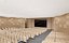 Elegante sala de conferências com painéis de madeira curvos e assentos em níveis.